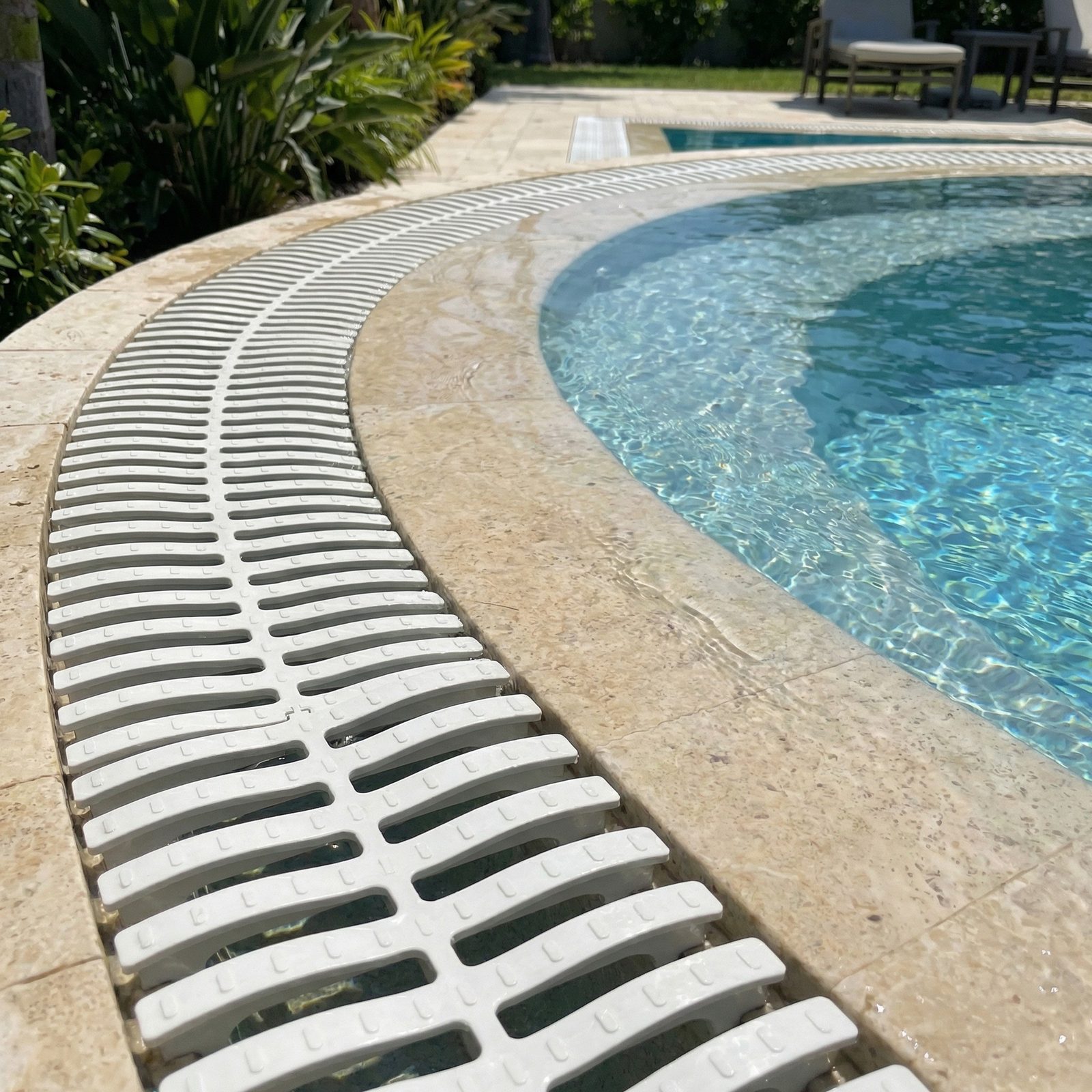 Grelha branca acompanhando a curva da borda da piscina